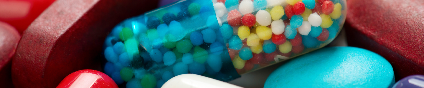 Closeup of a pile of bright-colored pills an capsules.