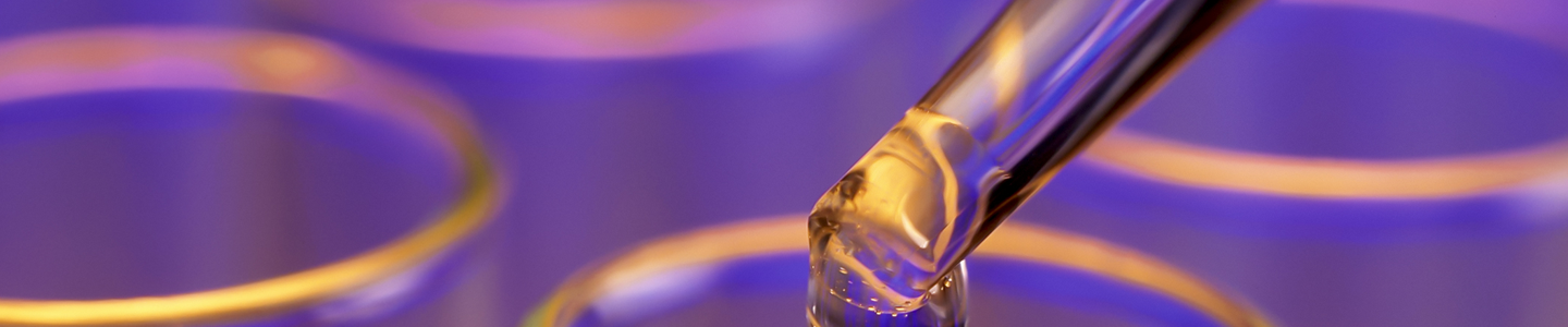 Eye dropper with drop of clear liquid, over top of row of test tubes.