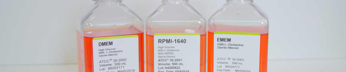 Capped clear bottles containing orange media, labeled: DMEM; RPMI-1640 high glucose with L-glutamine with HEPES; and EMEM.