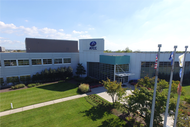 ATCC headquarters building and "ATCC" sign and flags in Manassas, Virginia.