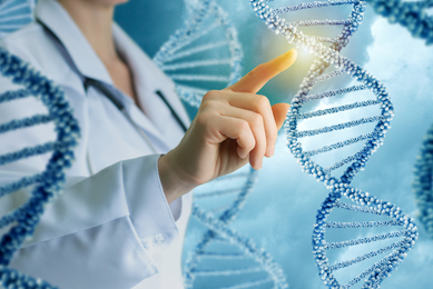 Strands of blue and white-beaded DNA double helixes floating in the air upright, with a woman in a lab coat touching a strand and light illuminating it.