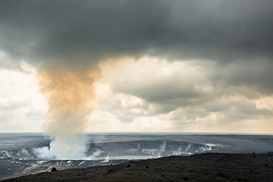 Gray fog and steam rising from the Halema'uma'u Crater within the K?lauea Caldera in Hawaii Volcanoes National Park.