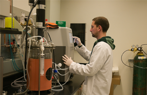 ATCC scientist standing at lab equipment.